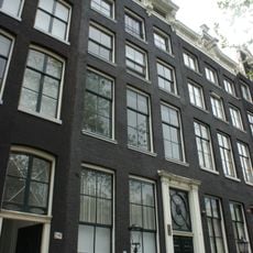 Pand met gevel onder verhoogde lijst met consoles en gesneden attiek