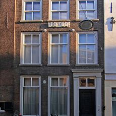 Pand met gevel met verkropte kroonlijst, hardstenen plint, gecanneleerde deurpilasters en originele vensterdorpels