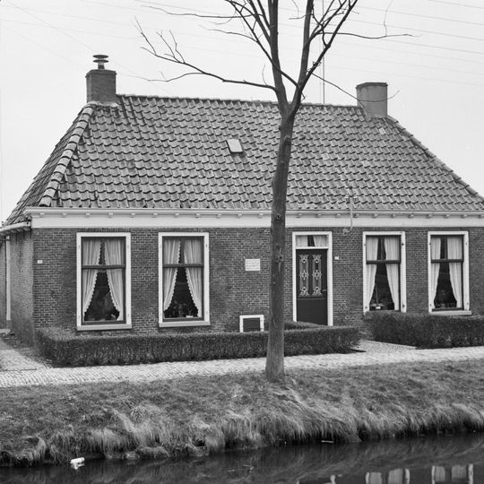 Dubbel landelijk pand met stichtingssteen en goot op klossen onder schilddak met twee hoekschoorstenen