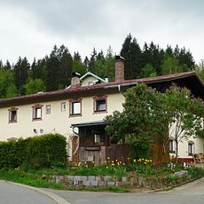 Stattliches massives Flachdachhaus mit zwei Rundbogentüren und Holzgiebel