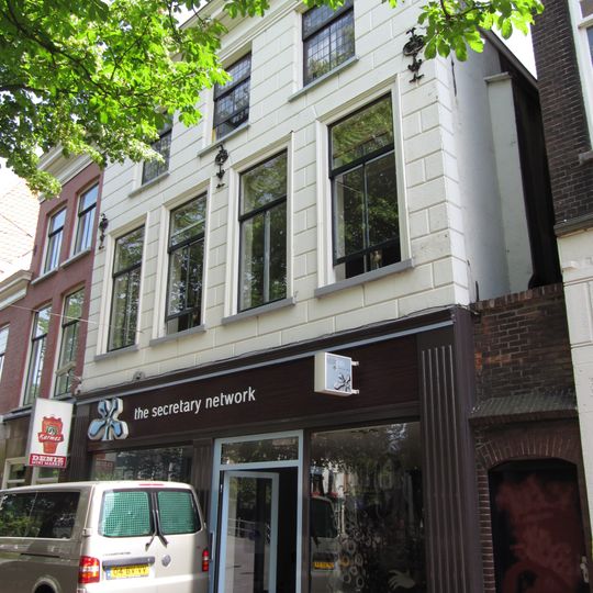 Pand onder hoog schilddak en met gepleisterde lijstgevel, waarin muurankers