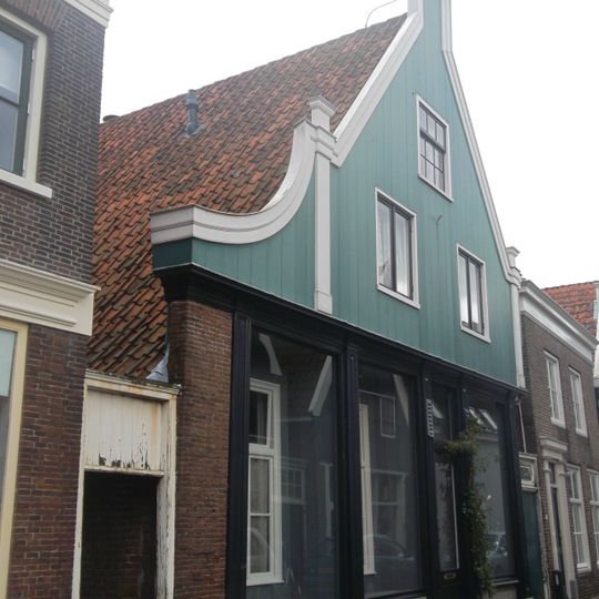 Huis met aan de straat een houten puntgevel met zijpilasters en links een ingezwenkt vleugelstuk