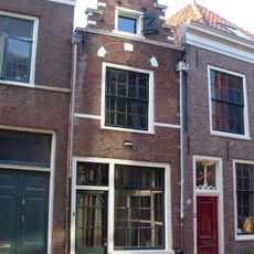 Pand met smalle trapgevel, eindigend in halfrond bovenstuk