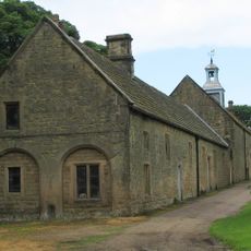 Range of outbuildings and stables, and walls enclosing a courtyard to south of Hardwick Hall