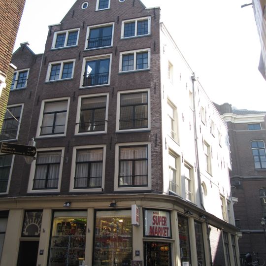 Hoekhuis met voorgevel aan de Grimburgwal onder punttop, een omlopende winkelpui