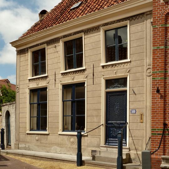 Gepleisterd pand bestaande uit een gedeelte met verdieping en schilddak