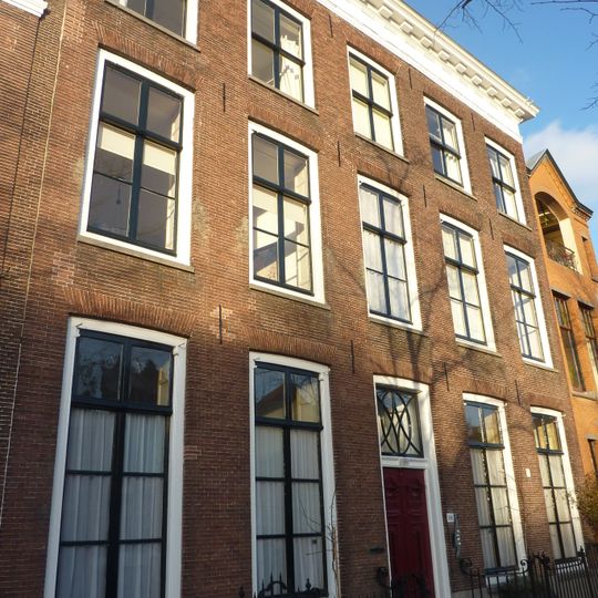 Pand met hoge bakstenen lijstgevel. Hardstenen stoep met ijzeren stoephek