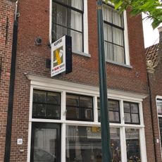 Pand met voorgevel met rechte kroonlijst en zesruitsvensters onder schilddak met topschoorsteen