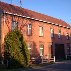 Bauernhof mit westlichem Wohnhaus (mit Durchfahrt) und drei Seitengebäuden eines geschlossenen Vierseithofes sowie östlich dahinterliegender Feldscheune Dorfstraße 28