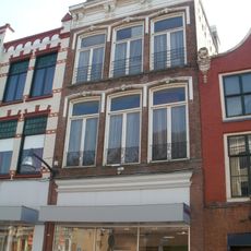 Pand met twee hoge verdiepingen afgesloten door brede lijst