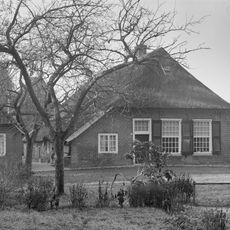 Boerderij onder een met pannen en riet gedekt afgewolfd zadeldak