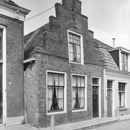 Pand onder zadeldak tegen trapgevel met overhoekse toppilaster