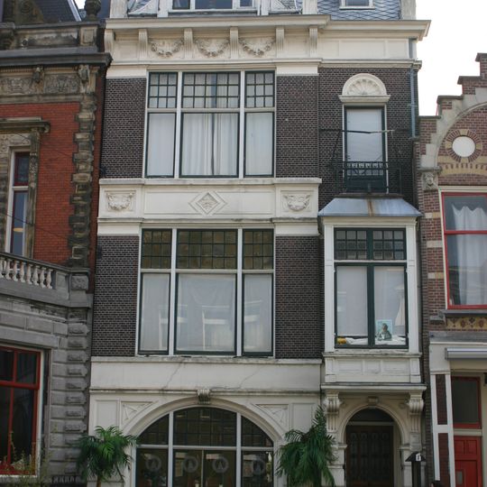 Herenhuis is in een donkerrode baksteen over drie bouwlagen opgetrokken op een rechthoekige plattegrond onder een afgeknot zadeldak met leien in Rijndekkin