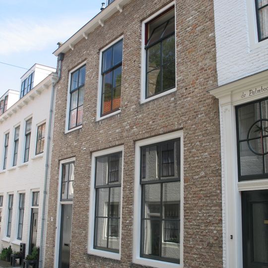 Huis met rechte gecementeerde gevel, op klossen rustende gootlijst