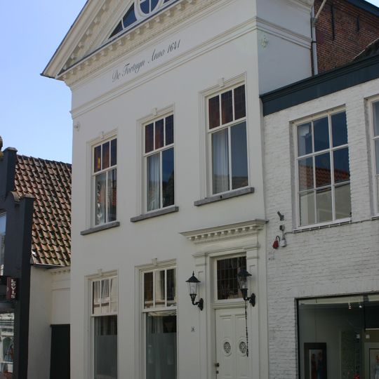 Huis met witgepleisterde klassicistische gevel, bekroond door een fronton met parellijsten en klossen