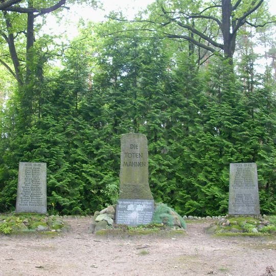 Denkmalanlage für die Gefallenen des Ortes im 1. und 2. Weltkrieg, drei Granitsteine mit Inschriften, Baumpflanzungen und Gehölze entlang der zentralen Wegeachse