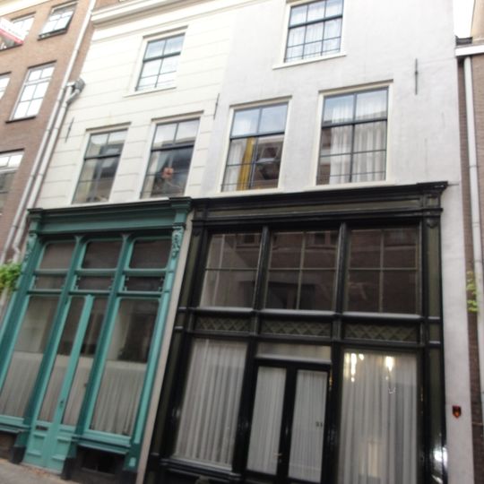 Recht helft van in twee woningen gesplitst, breed, onderkelderd, laat-gotisch huis