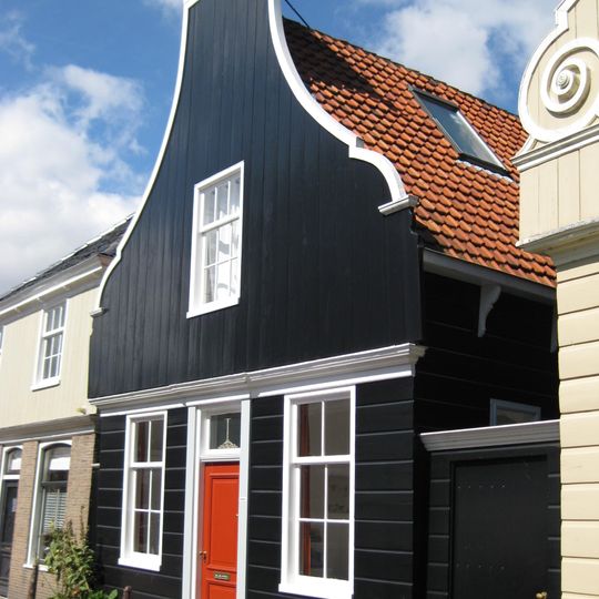 Houten dijkhuis met klokgevel uit 19de eeuw, met puntgevel aan achterzijde