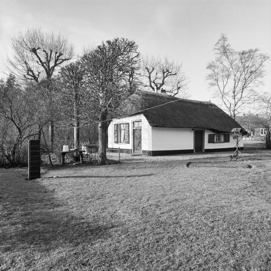 Witgepleisterd landarbeidershuisje onder met rietgedekt schilddak