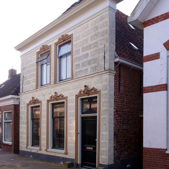 Pand met gepleisterde lijstgevel onder met pannen gedekt schilddak met topschoorstenen