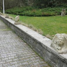 Drobné kamenné plastiky na zídce nádvoří nového pavilonu Prusíkova pramene v Konstantinových Lázních