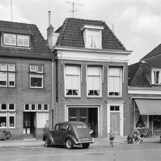 Vier traveeën breed pand met rechte kroonlijst onder zadeldak met voorschild