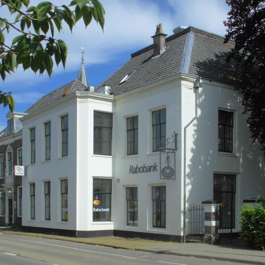 Witgepleisterd huis met rechte kroonlijst, rechthoekig grondplan en uitgebouwde kamer