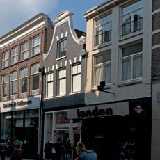 Pand met gepleisterd klokgeveltje en jongere onderpui