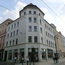 Mietshaus mit Laden in geschlossener Bebauung, Eckhaus Berliner Straße 15 (Hauptanschrift: Hospitalstraße 8)