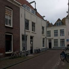 Apart genummerde ingang in gepleisterde zijgevel van het pand Wagenaarstraat 11