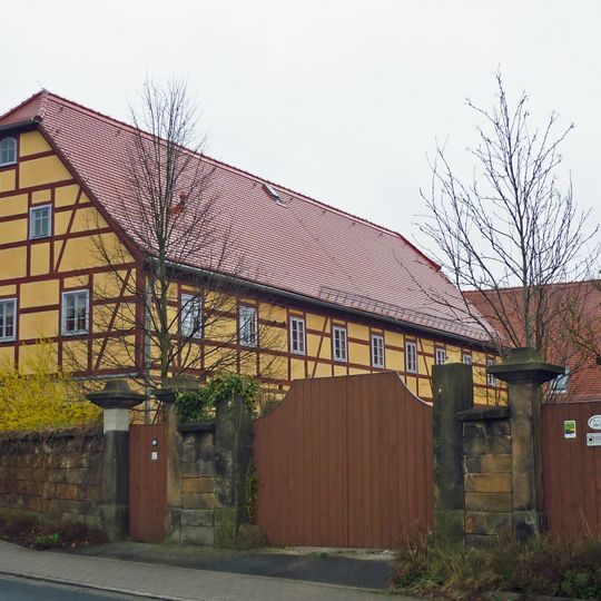 Wohnstallhaus und Scheune eines Bauernhofes mit Einfriedung, Hofmauer und Toreinfahrt Basteistraße 80
