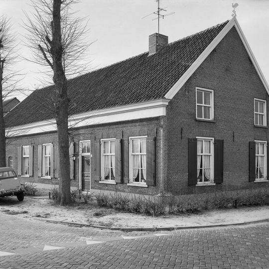 Boerderij van het traditionele Brabantse langgeveltype. Pannen zadeldak tussen puntgevels, houten kroonlijst en vensters met zesruitsschuiframen en luiken