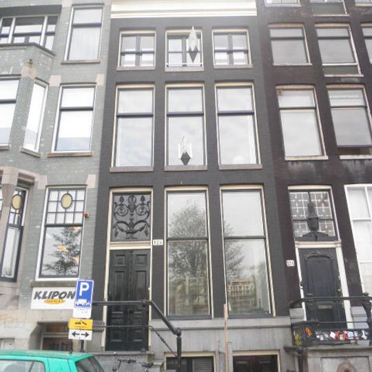 Pand met gevel onder gesneden rechte lijst met empire deurpartij, balusters en stoephek