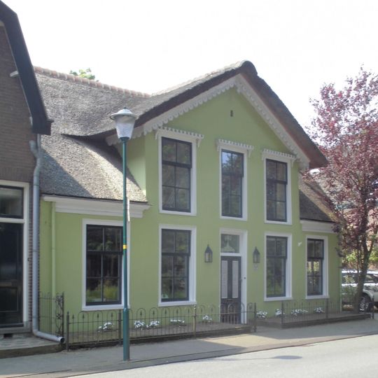 Dubbelbeukig pand waarvan de voorste en hoogste beuk aan de straatzijde is afgesloten met een lijstgevel die voor wat de middelste drie traveeën betreft met een verdieping verhoogd is