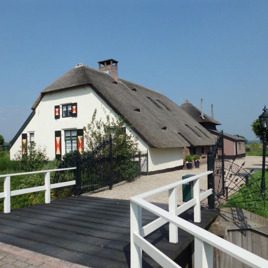 Boerderij van het voerdeeltype, gedeeltelijk gepleisterd bakstenen gebouw onder afgewolfd zadeldak van riet en pannen
