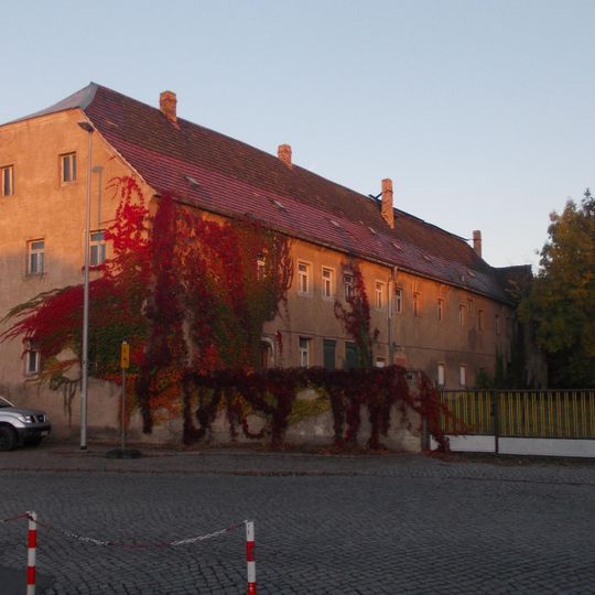 Wohnhaus, Hofpflasterung, Einfriedungsmauer und Reste der Scheune eines Stadtgutes Bahnhofstraße 1