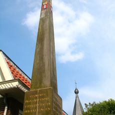 Banpaal in de vorm van een natuurstenen obelisk op bakstenen voet