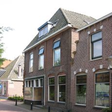 Gaaf breed pand onder tentdak met bewerkte deur