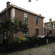 Blok van vier rug-aan-rug gebouwde woningen op vierkante plattegrond, bestaande uit begane grond en verdieping onder een plat dak