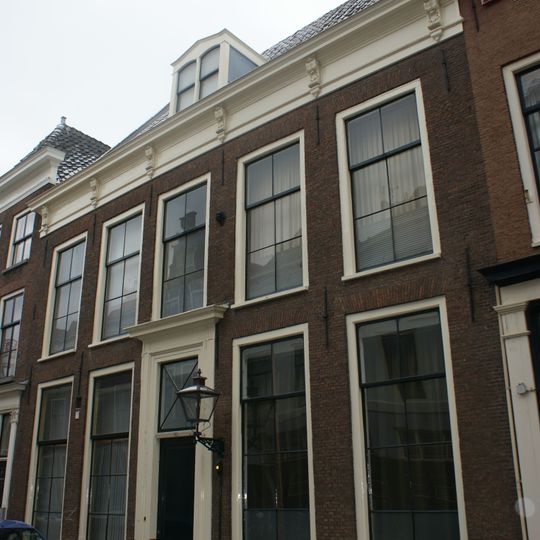 Pand met brede gevel met rechte consoles kroonlijst, ingang bovenlicht met aloeplant