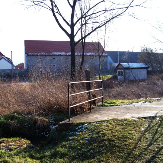 Můstek přes Všeradický potok na stezce mezi kostelem a muzeem ve Všeradicích