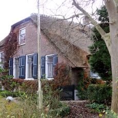 Grote boerderij met in de 19e eeuw vernieuwde voorgevel