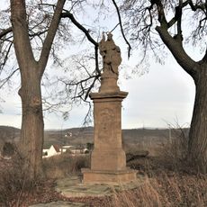 Opravený podstavec rozbitého kříže v Řehlovicích u silnice na Hbrovany
