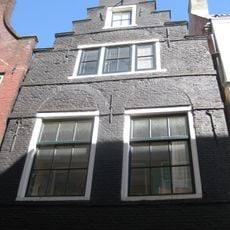 Pand met trapgevel verwant aan het 'type-met-kleine-blokjes', doch geheel in baksteen uitgevoerd