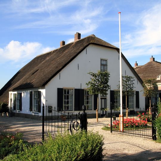 Boerderij, gepleisterd langhuis, afgewolfde topgevel, met riet gedekt