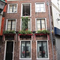 Huis met gevel onder rechte lijst met triglyfen