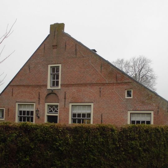 Huis met aan een zijde flauwhellend dak, horizontale lijsten, bogen boven de vensters