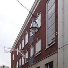 Pand met gepleisterde lijstgevel en deur met snijwerk en bovenlicht