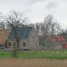 Bakstenen woonhuis met pannen zadeldak. Bakgoot op klossen. Dicht bijeen liggende staafankers aan lange zijden. Eenruits ramen met rollagen. Deur met eenruits bovenlicht.