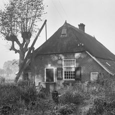 Boerderijtje onder een met riet en pannen gedekt afgewolfd zadeldak